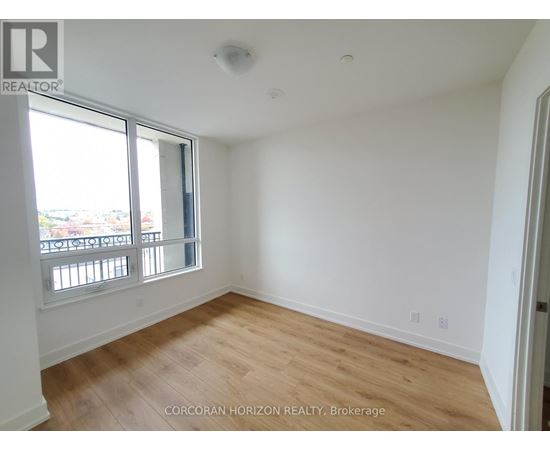 A room with a large window and wooden flooring.