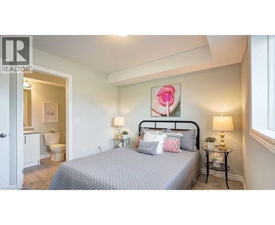 A bedroom with a bed, nightstands, and a painting of a rose.