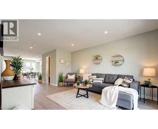 A living room with a grey couch and a white blanket on it.