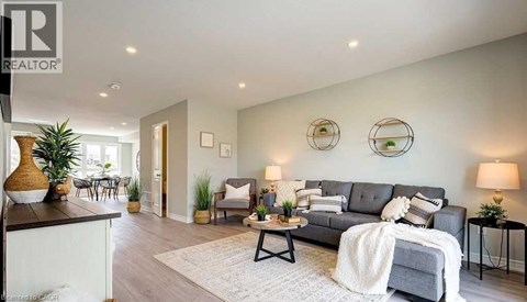 A living room with a grey couch and a white blanket on it.