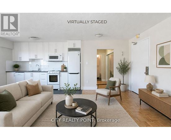 A modern living room with a white kitchen in the background.