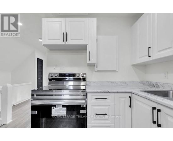 A kitchen with white cabinets and a stainless steel oven.