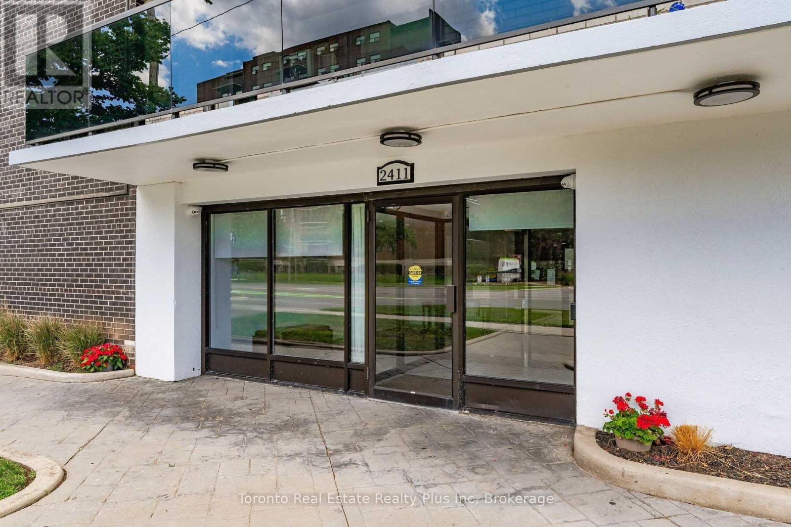 The entrance to a building with a glass door and a number 2411 on the wall.