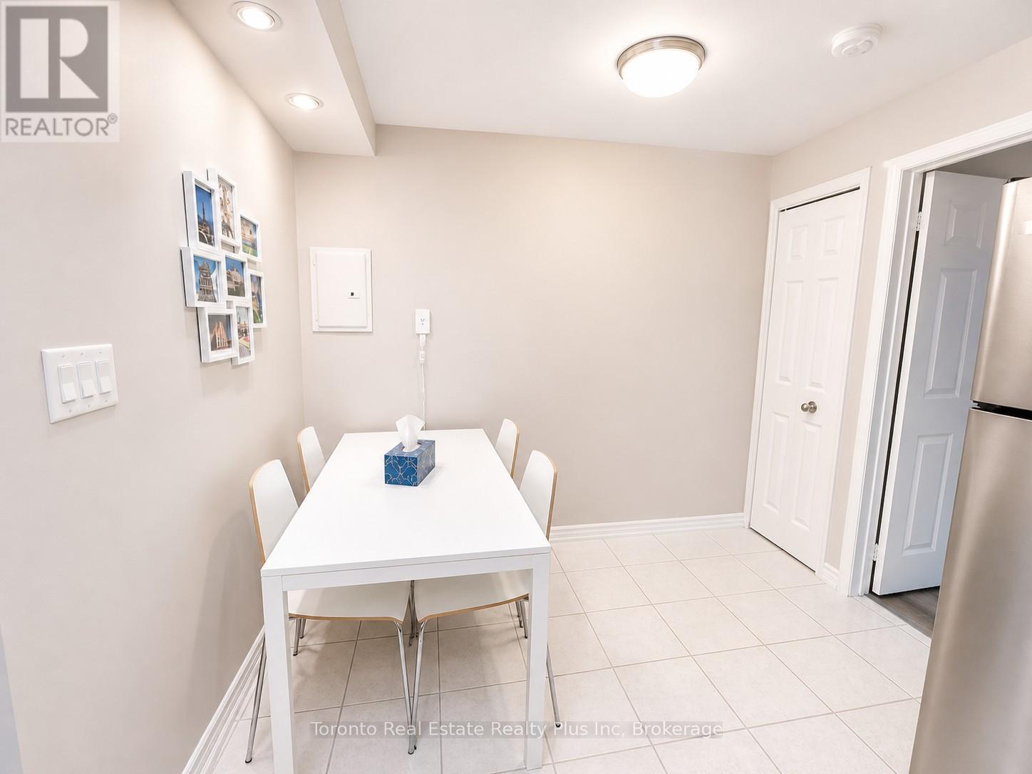 A dining room with a white table and chairs.