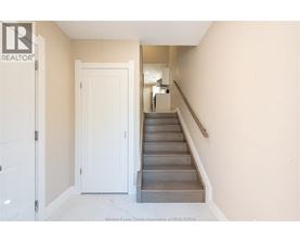 A hallway with a staircase and a door.