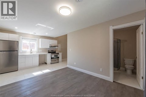 A kitchen with a refrigerator, sink, and a window.