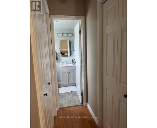A bathroom with a sink and mirror is visible through an open door.