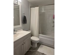 A white toilet sits next to a sink in a bathroom.
