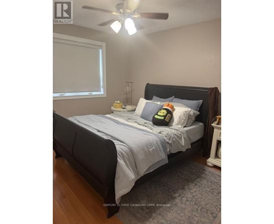 A bedroom with a bed, nightstand, and window.