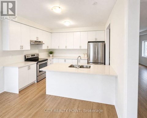 A kitchen with white cabinets and a wooden floor.