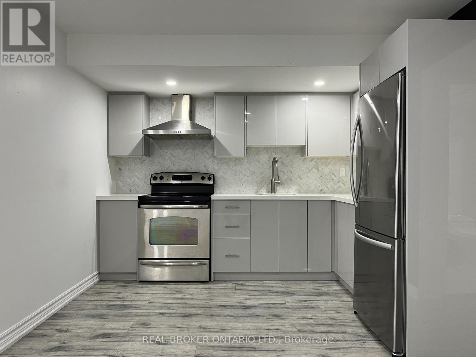 A modern kitchen with a stainless steel oven and refrigerator.