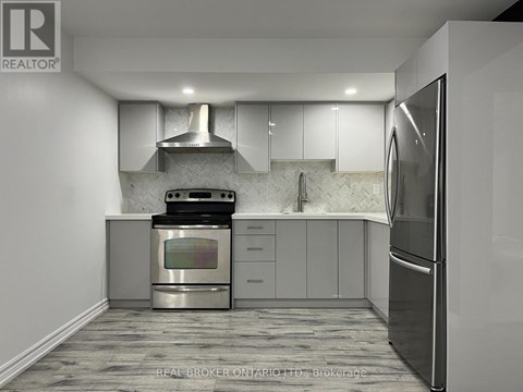 A modern kitchen with a stainless steel oven and refrigerator.
