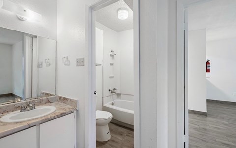 A white bathroom with a toilet, sink, and bathtub.