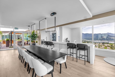 A modern dining room with a long table and chairs.