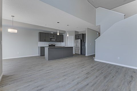 A spacious kitchen with a grey countertop and cabinets.
