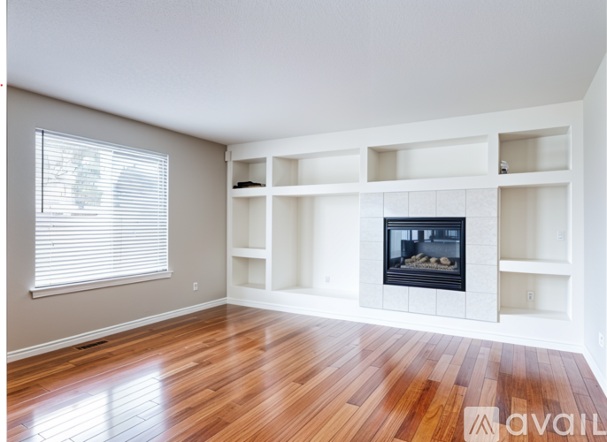 A living room with a fireplace and wooden floors.