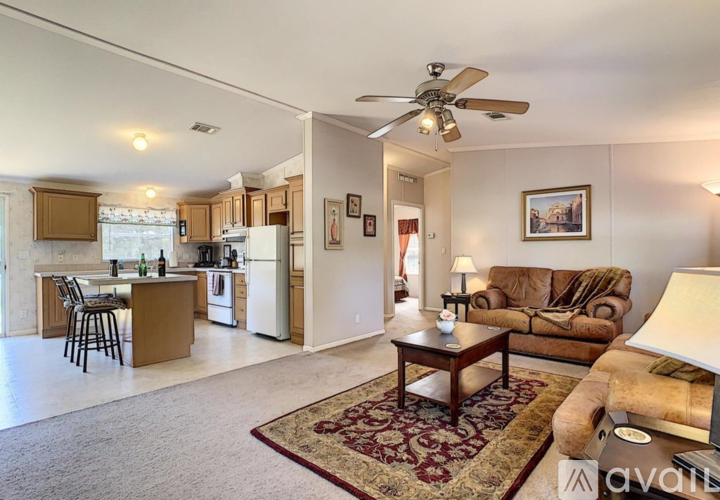 A living room with a brown couch and a rug.