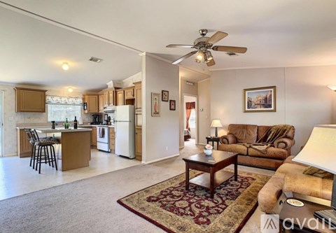 A living room with a brown couch and a rug.