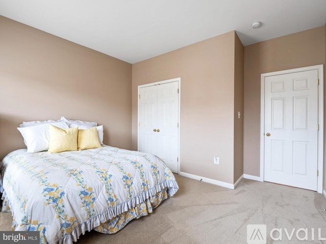 A bedroom with a bed and two doors.
