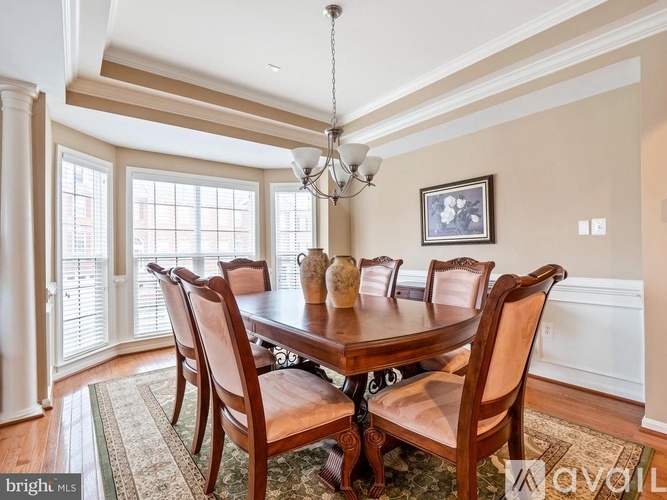 A dining room with a wooden table and chairs.