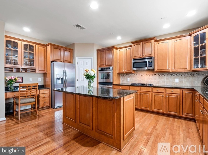 A kitchen with wooden cabinets and a black countertop.