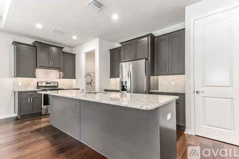 A modern kitchen with dark brown cabinets and a white island.