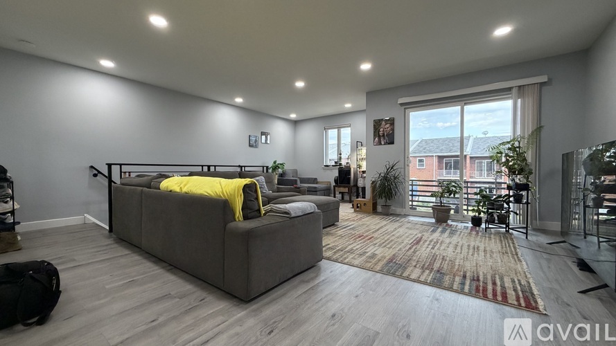 A living room with a grey sofa and a rug.