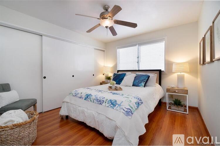 A bedroom with a bed, a ceiling fan, and a window with blinds.
