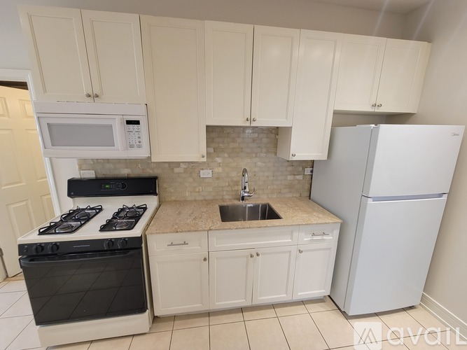 A kitchen with white cabinets and appliances.