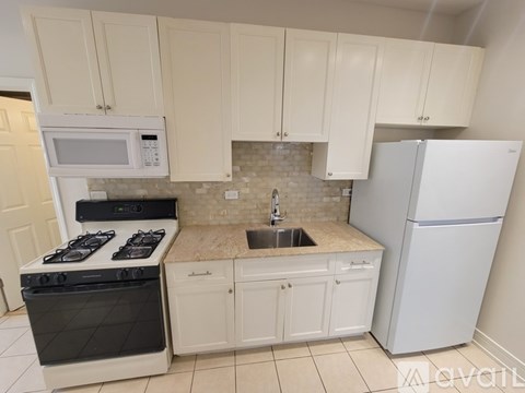 A kitchen with white cabinets and appliances.