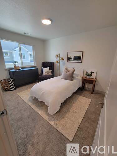 A bedroom with a bed, a couch, and a rug.