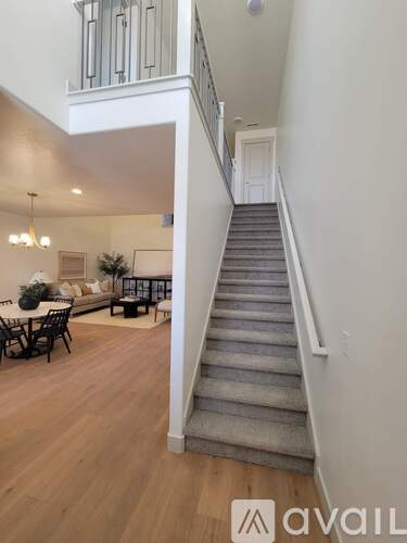 A staircase in a home with a dining area visible in the background.