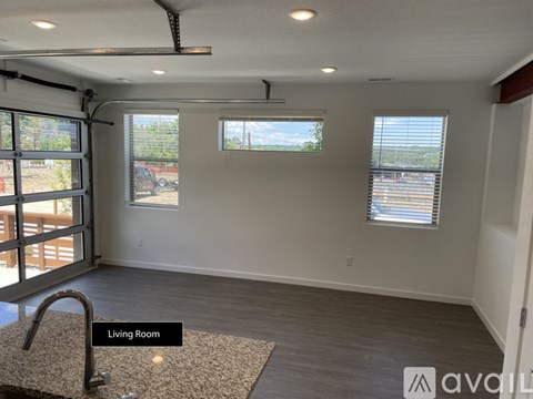 A living room with a rug and a window.