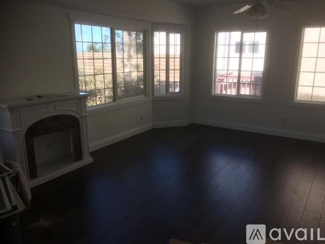 A living room with a fireplace and a fan.
