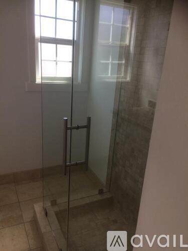 A glass shower door with a handle is in the foreground.