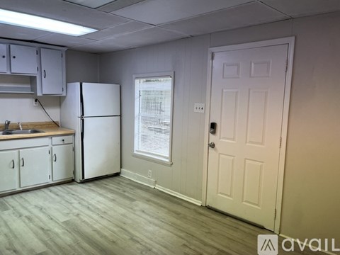 A kitchen with a white refrigerator and cabinets.