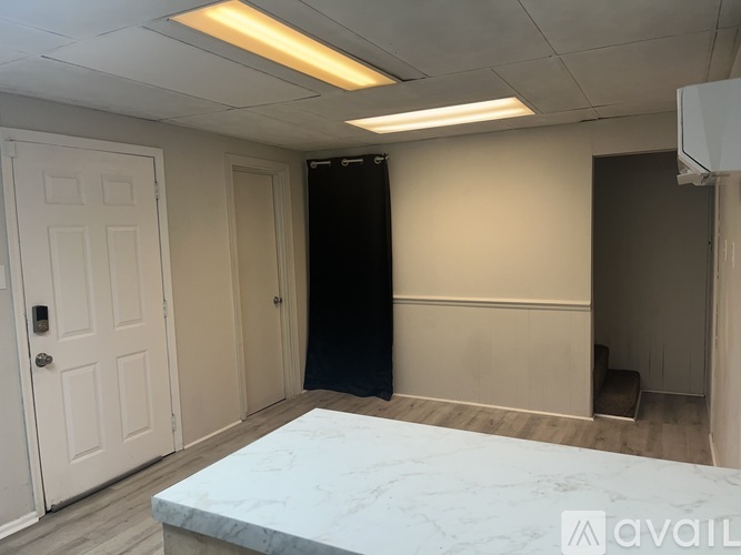 A room with a marble table and a black wardrobe.