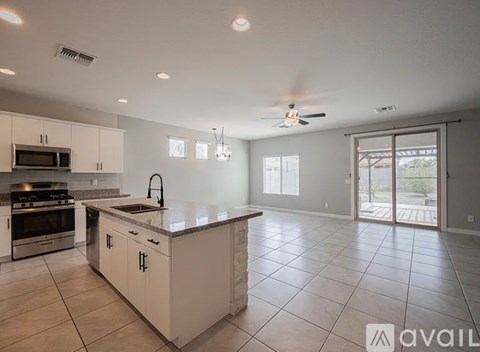 A spacious kitchen with white cabinets and a large island.