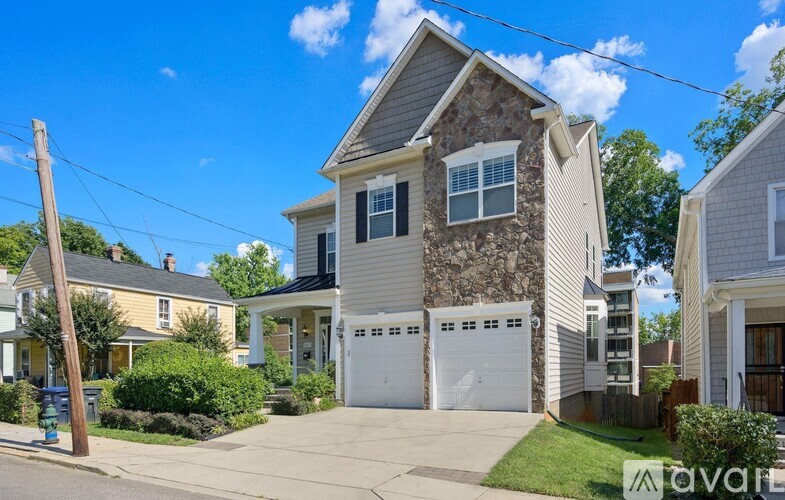 A two-story house with a garage is situated in a residential area.