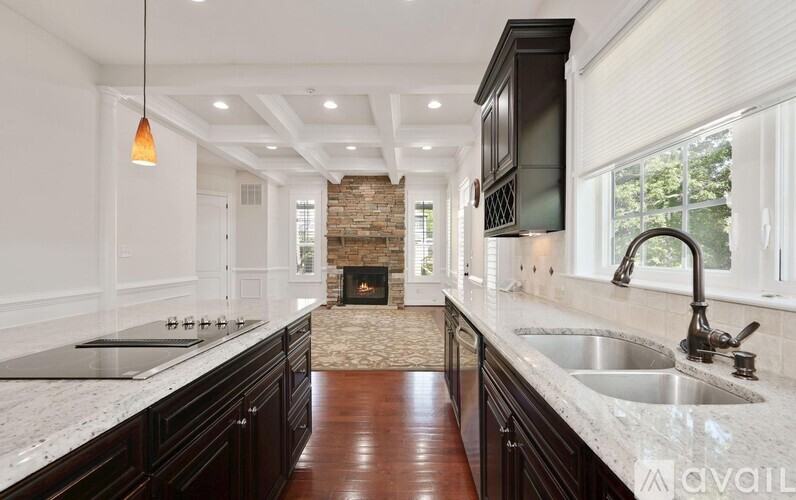 A kitchen with dark wood cabinets and a marble countertop.