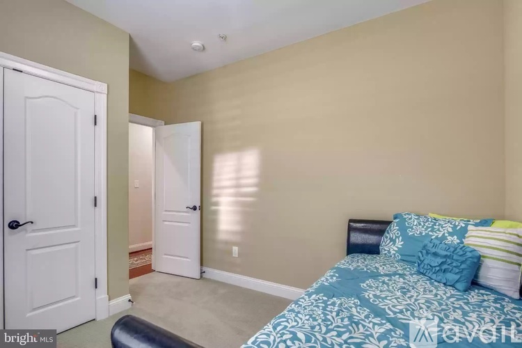 A bedroom with a bed and two doors.