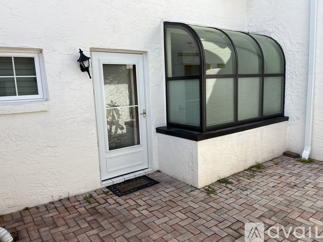 A white door with a glass window is on a white wall.
