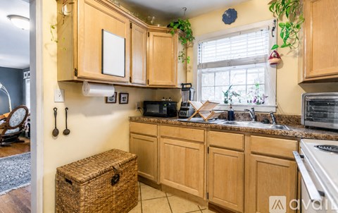 A kitchen with wooden cabinets and a countertop with a microwave and oven.