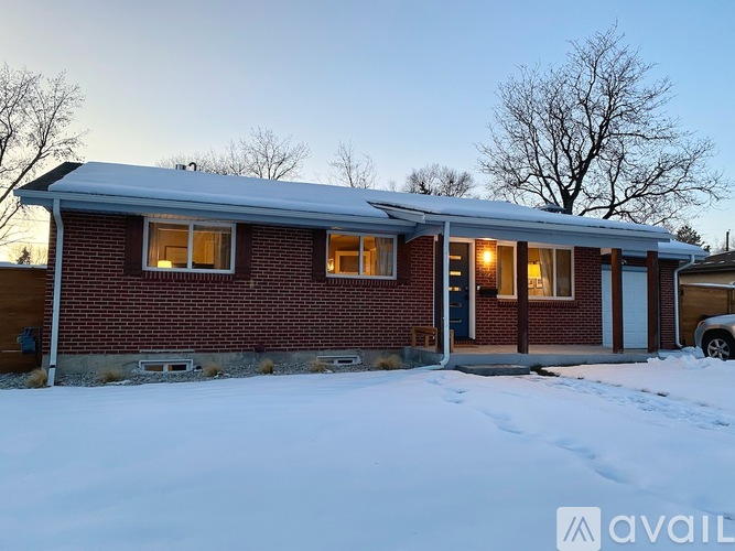 A house with a snow-covered ground in front of it.