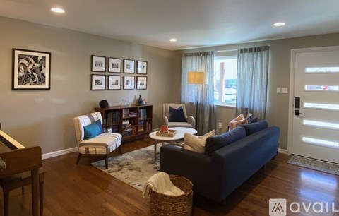 A living room with a couch, chair, and a table with a lamp.