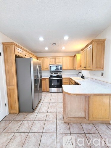 A kitchen with wooden cabinets and a tile floor.