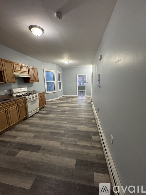 A long hallway with wood floors and white walls.