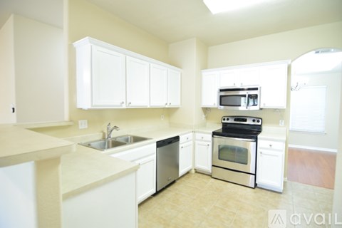 A kitchen with white cabinets and appliances.