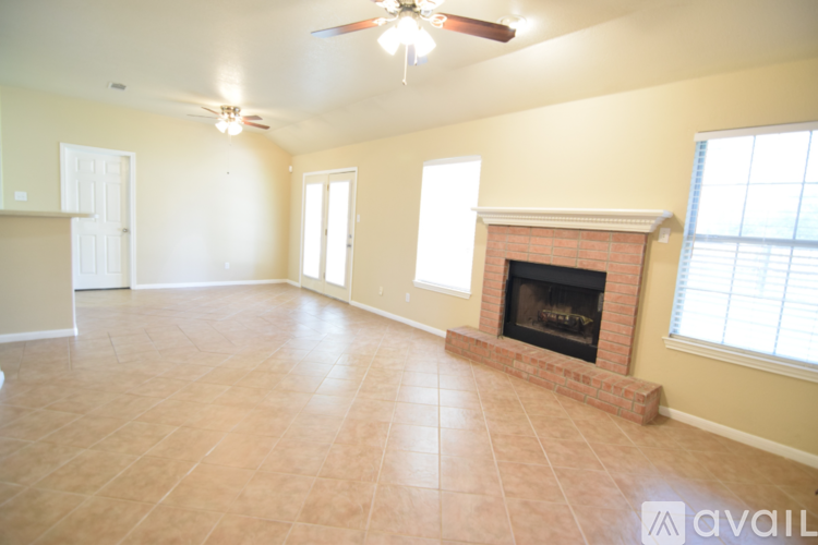 A living room with a fireplace and a ceiling fan.