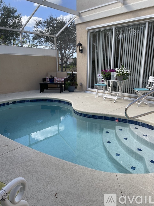 A pool with a bench and a table with chairs.